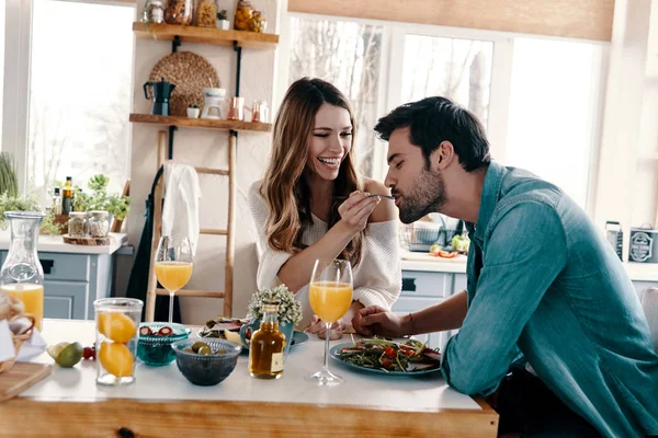 自宅の台所で座っている間健康的な朝食を楽しんで美しい若いカップル — ストック写真