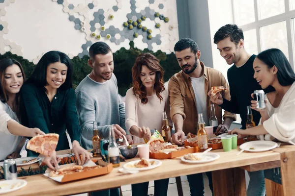 Grupo Jóvenes Ropa Casual Comiendo Pizza Sonriendo Mientras Hacen Una —  Fotos de Stock