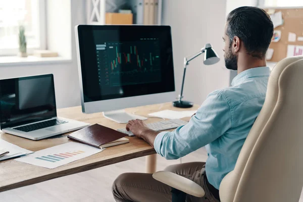 Young Modern Businessman Analyzing Data Using Computer While Sitting Office — 스톡 사진