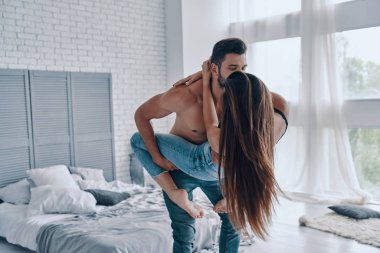 mutlu Güzel genç çift yatak odasında yüz yüze dururken kucaklayan, adam öpüşme kadın 
