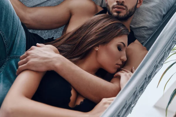 美丽的年轻夫妇拥抱 而睡在室内的吊床的顶视图 — 图库照片
