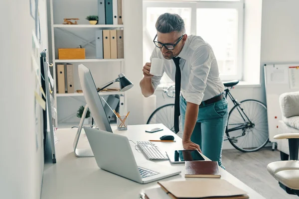 Joven Guapo Bebiendo Café Sonriendo Mientras Está Pie Oficina — Foto de Stock