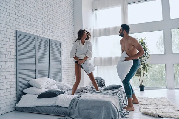 Full Length Happy Young Couple Having Fun Pillow Fight While — Stock Photo, Image