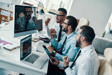 Başarı, Resmi giyim ve ofiste çalışırken gülümseyen genç modern erkeklerin Grubu