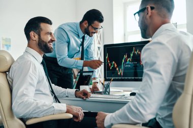 Pazar büyüyor, formalwear genç modern erkek grubu ofiste çalışırken borsa verilerini analiz     