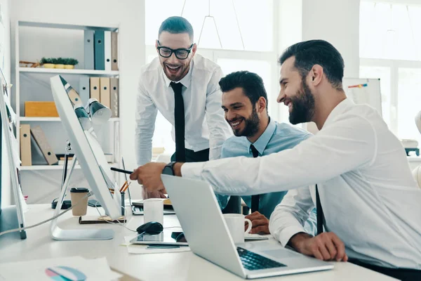 正しい決断を求めて オフィスに座っている間にコンピュータを使って働くフォーマルウェアを着た若い現代男性のグループ — ストック写真