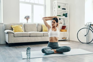 Sabah egzersiz, evde vakit geçirirken spor giyim yoga güzel genç kadın                        