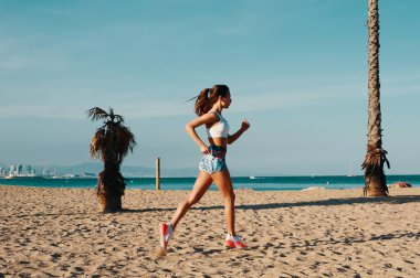 Açık havada egzersiz yaparken spor giyim koşu güzel genç kadın tam uzunlukta