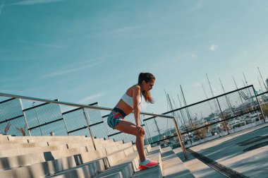 Açık havada egzersiz yaparken rahatlatıcı spor giyim güzel genç kadın tam uzunlukta