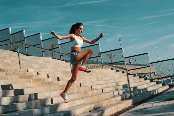 屋外で運動しながら走るスポーツウェアの美しい若い女性の完全な長さ — ストック写真