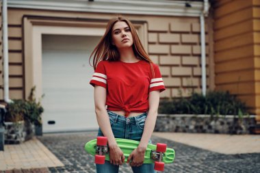 Güzel genç kadın açık havada dururken kameraya bakıyor 