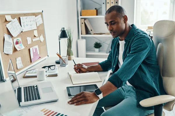 자신감 사업가 사무실에 앉아있는 노트북을 사용하여 셔츠에 아프리카 — 스톡 사진