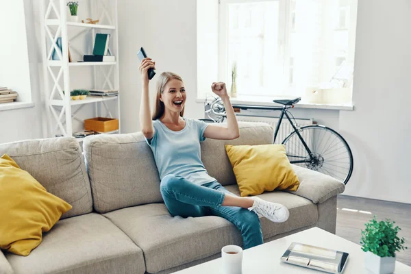 Mulher Bonita Animando Sorrindo Enquanto Assiste Sofá Casa — Fotografia de Stock