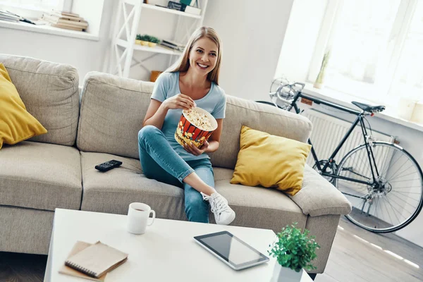 Mulher Bonita Comendo Pipocas Sorrindo Enquanto Assiste Sofá Casa — Fotografia de Stock