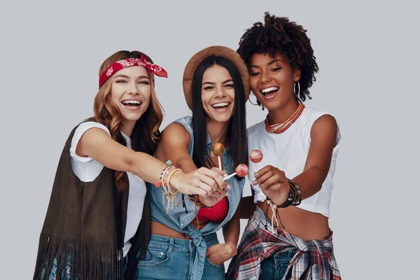 Three Attractive Young Women Eating Lollipop Smiling While Standing Grey — Stock Photo, Image