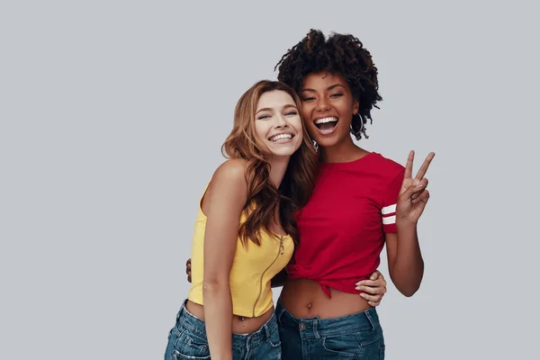 Дві Привабливі Молоді Жінки Дивляться Камеру Посміхаються Стоячи Сірому Фоні — стокове фото