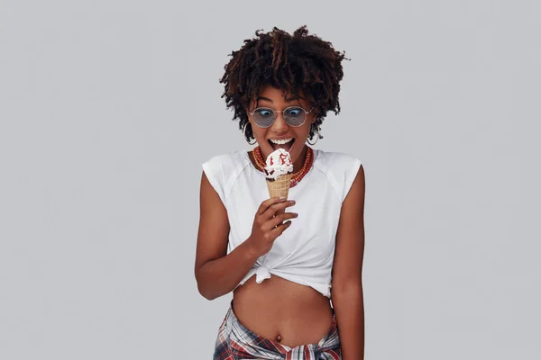 Привлекательная Молодая Африканская Женщина Ест Мороженое Улыбается Стоя Сером Фоне — стоковое фото