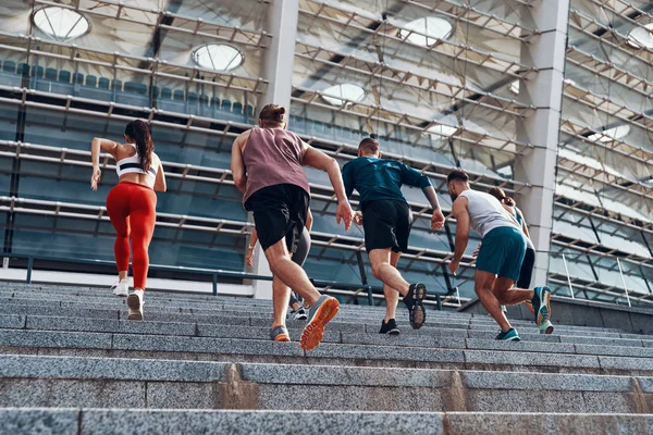 Gruppe Junger Leute Sportkleidung Joggt Auf Treppen Der Stadt Olympiastadion — Stockfoto