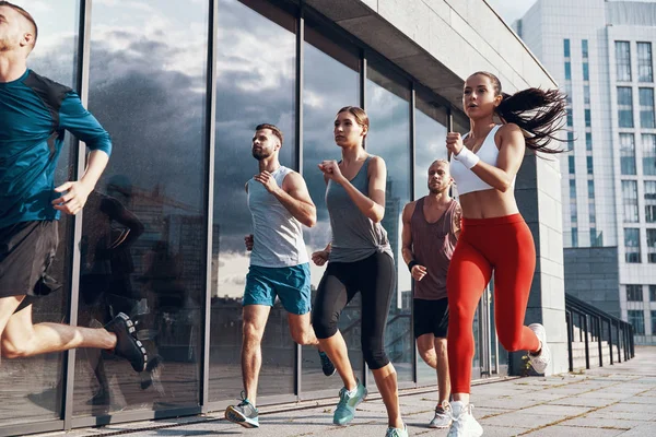 Grupo Personas Ropa Deportiva Corriendo Aire Libre Ciudad Edificio Moderno —  Fotos de Stock