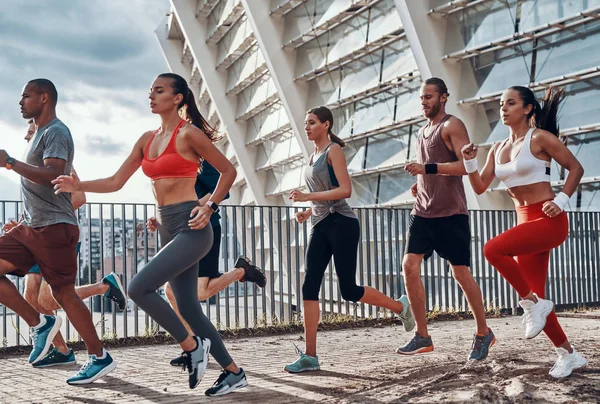 Pełna Długość Młodych Ludzi Odzieży Sportowej Jogging Podczas Ćwiczeń Zewnątrz — Zdjęcie stockowe