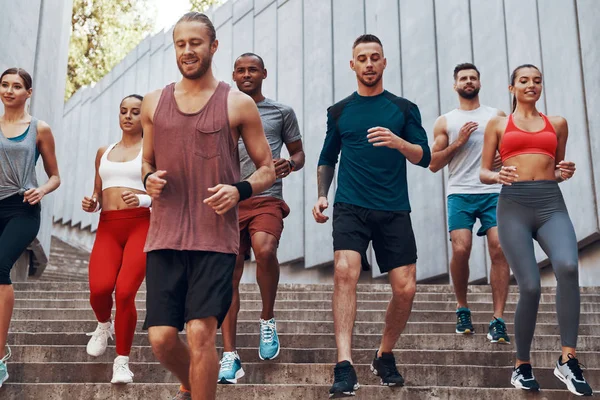 Grupo Personas Ropa Deportiva Trotando Mientras Hacen Ejercicio Los Escalones —  Fotos de Stock