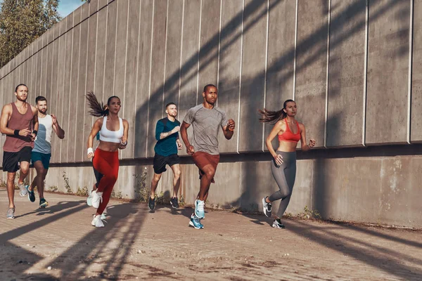 Pełna Długość Ludzi Odzieży Sportowej Jogging Podczas Ćwiczeń Chodniku Zewnątrz — Zdjęcie stockowe