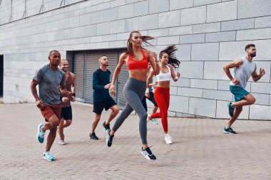 Kaldırımda açık havada egzersiz yaparken spor giyim koşu gençlerin tam uzunlukta 