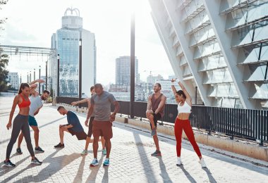 spor giyim sportif insanlar ısınma ve germe açık havada egzersiz yaparken 