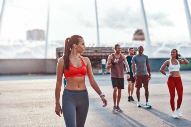 Spor giyimli bir grup genç şehirde yürüyor 