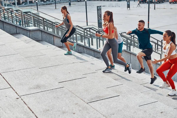 Grupo Jóvenes Ropa Deportiva Trotando Escaleras Hormigón Ciudad — Foto de Stock