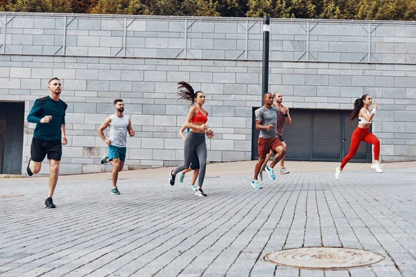 Full Längd Unga Människor Sportkläder Jogging Medan Tränar Utomhus — Stockfoto