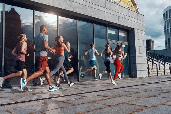 Группа Людей Спортивной Одежде Бегают Городу Современном Здании Стеклянными Окнами — стоковое фото