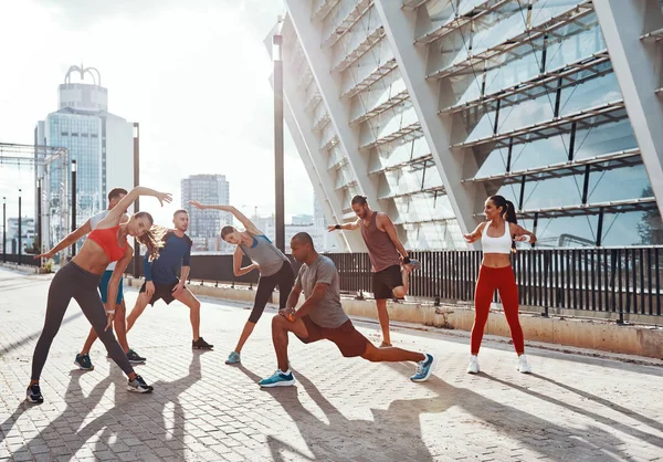 运动型运动的人穿着运动服装在户外运动时热身和伸展 — 图库照片