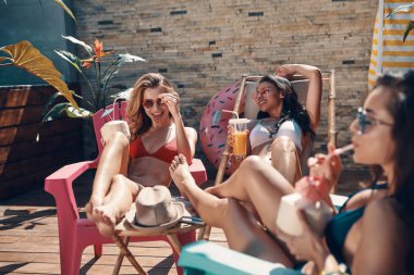 Tropik tatil de rahatlatıcı ve hindistan cevizi kokteylleri olan mayo çekici genç kadınlar