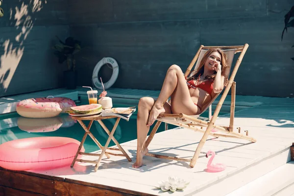 Havuz Başında Açık Havada Güneşlenirken Bikinili Çekici Genç Kadın Dinlendirici — Stok fotoğraf