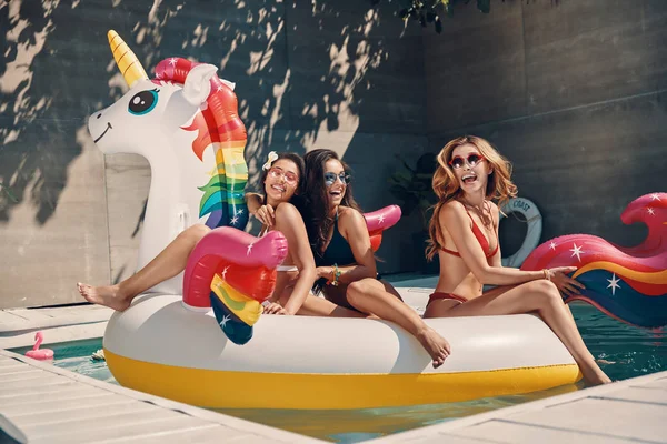 Atractivas Mujeres Jóvenes Traje Baño Sonriendo Mientras Flotan Unicornio Inflable — Foto de Stock