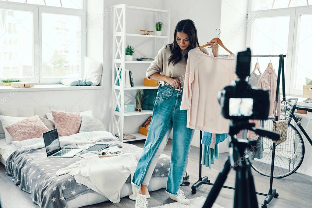 Beautiful brunette woman making social media video and promoting clothes 