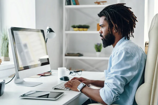 Tänksam Ung Afrikansk Man Som Använder Dator När Han Arbetar — Stockfoto