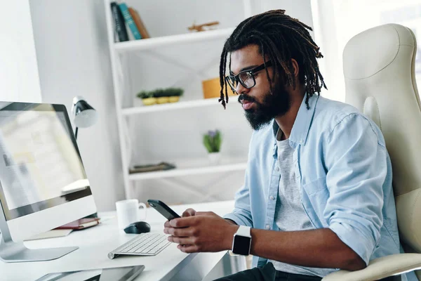 Stilig Ung Afrikansk Man Glasögon Med Smartphone När Arbetar Kontoret — Stockfoto