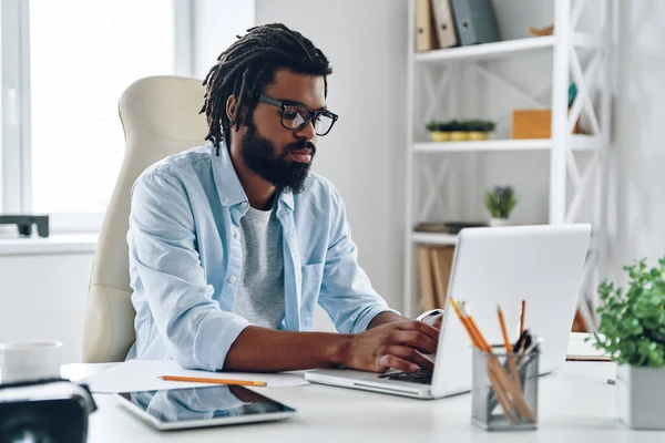 Pensativo Joven Africano Gafas Usando Computadora Mientras Trabaja Oficina —  Fotos de Stock