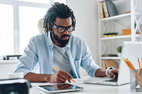 Bedachtzame Jonge Afrikaanse Man Brillen Met Behulp Van Computer Tijdens — Stockfoto