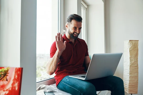 Feliz Joven Con Ropa Casual Usando Ordenador Portátil Saludando Mientras — Foto de Stock