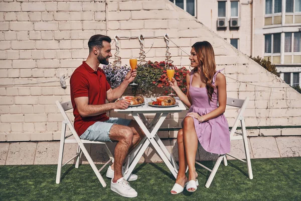 Zorgeloos Jong Stel Casual Kleding Drinken Sap Glimlachen Terwijl Zitten — Stockfoto