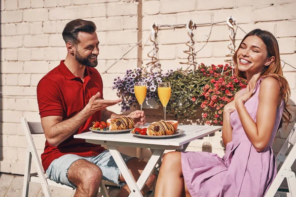 Pareja Joven Despreocupada Ropa Casual Desayunando Sonriendo Mientras Está Sentada —  Fotos de Stock