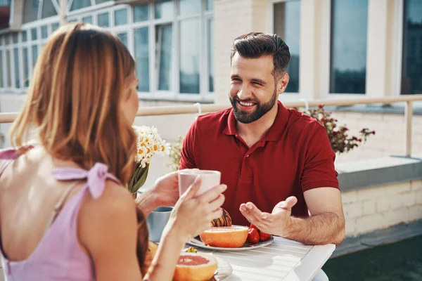 Pareja Joven Despreocupada Ropa Casual Disfrutando Cena Sonriendo Mientras Sienta —  Fotos de Stock