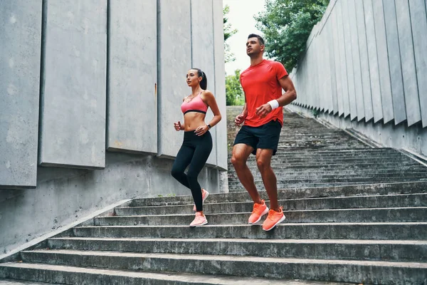 Panjang Penuh Dua Atlet Dalam Pakaian Olahraga Berlari Menuruni Tangga — Stok Foto