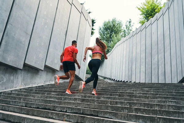 屋外で練習しながら階段を駆け上がる2人のアスリートの完全な長さ — ストック写真