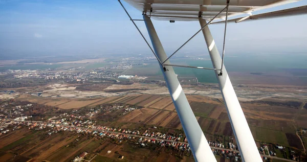 Low angle view of airplane wing and window view of village