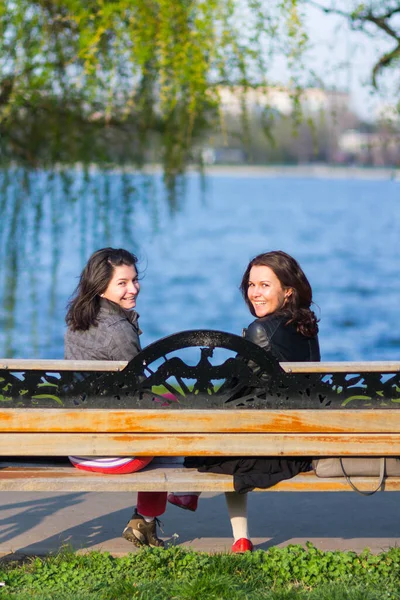 Dos Mujeres Sentadas Banco Parque Sonriendo Cámara — Foto de Stock