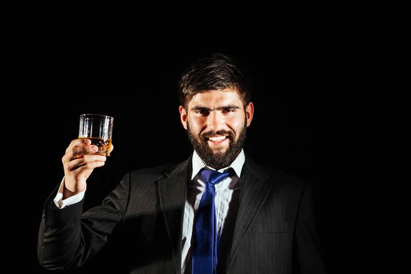 Hombre Negocios Sonriente Sosteniendo Vaso Whisky Sobre Fondo Oscuro — Foto de Stock